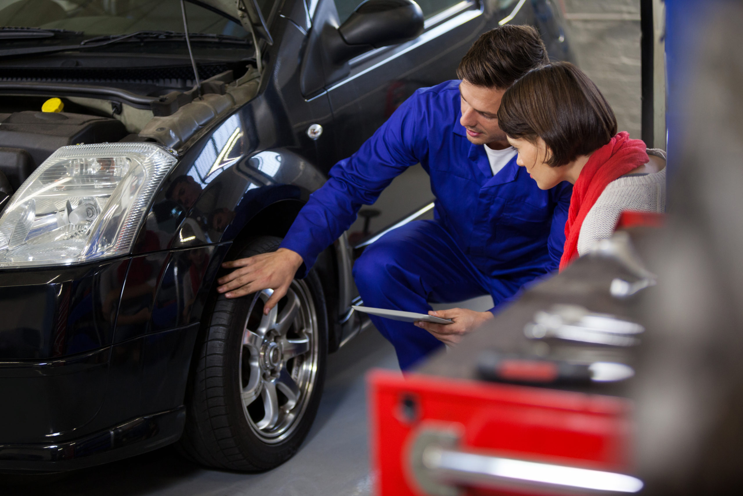 Mechanic showing customer the problem with car Essential vehicle care services